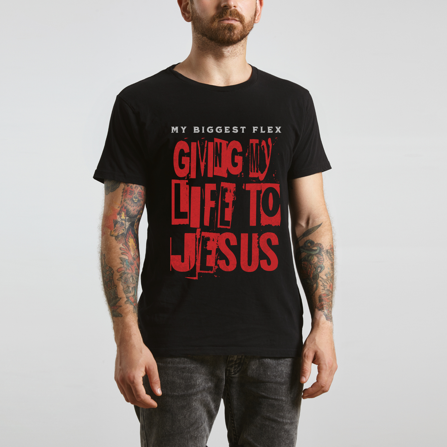 man wearing a black christian streetwear graphic t-shirt that says my biggest flex giving my life to Jesus