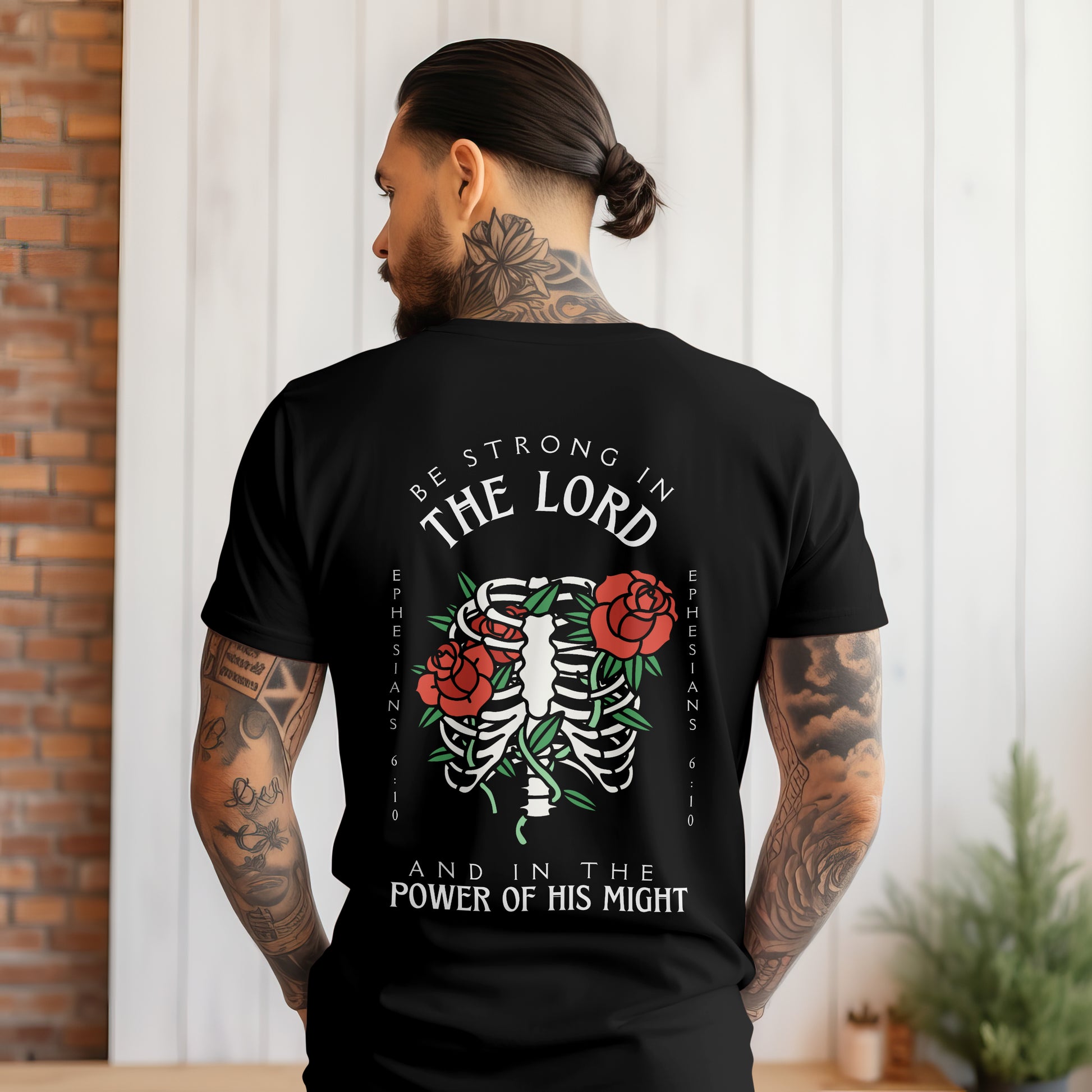 mens christian tee with a bible verse back side design that says be strong in the lord and in the power of his might with a rib cage and roses in the traditonal tattoo style art