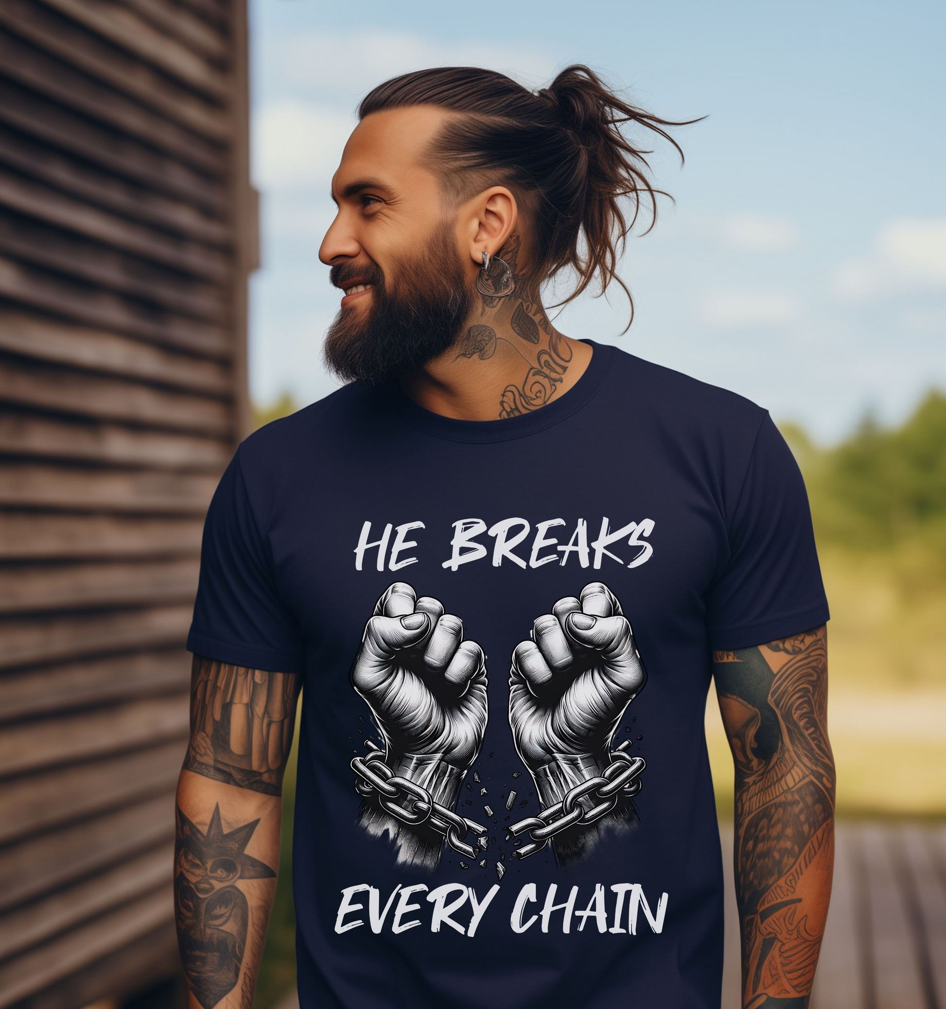 man wearing a navy crewneck short sleeve christian graphic t-shirt that says He Breaks Every Chain featuring the image of hands breaking free from chains